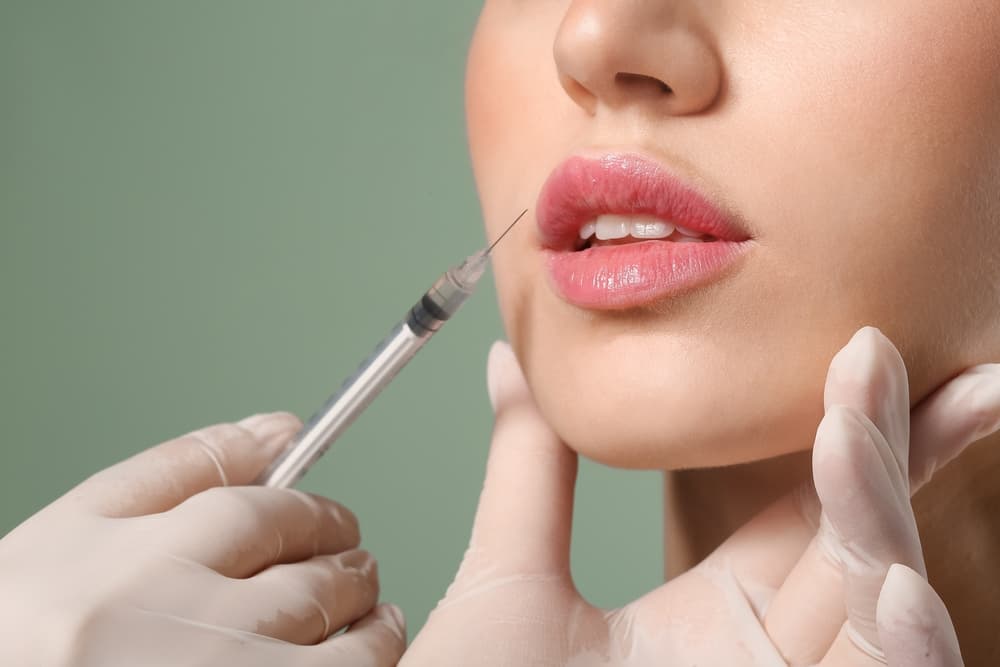 Young woman receiving lip filler injections.